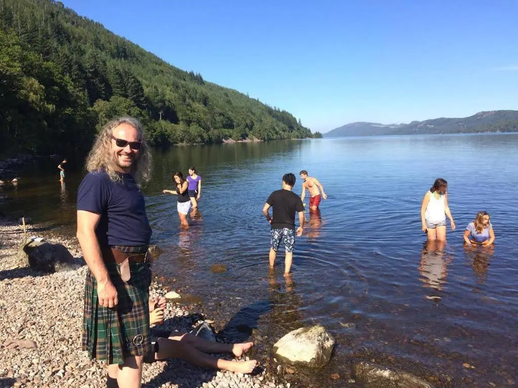 a group of people in the water at a lake at Loch Ness Lochside Hostel - Over 16s Only in Invermoriston