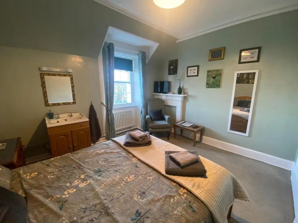 a bedroom with a bed with two towels on it at Forse of Nature in Latheron