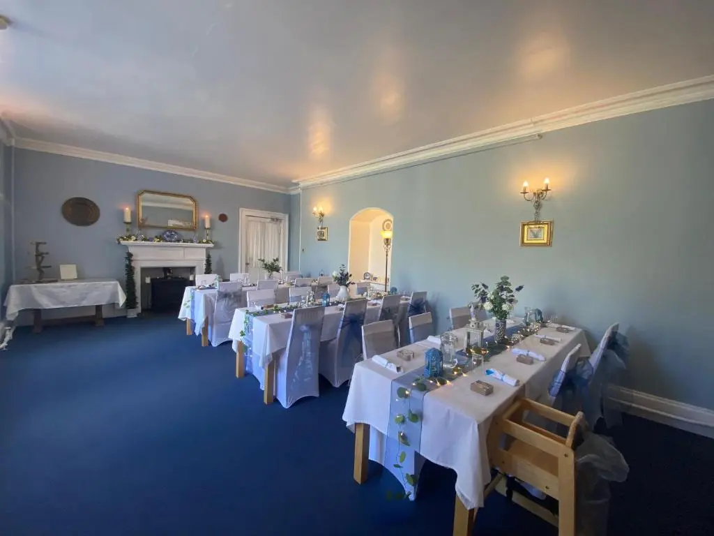 a room with tables and chairs with white tablecloths at Forse of Nature in Latheron