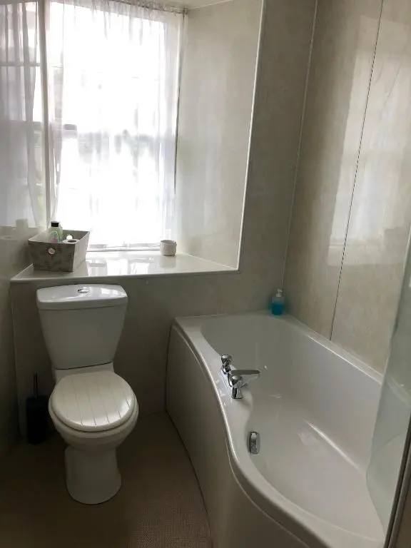 a bathroom with a toilet and a tub and a window at Forse of Nature in Latheron