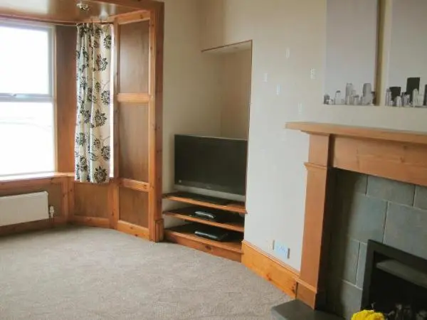 a living room with a television and a fireplace at House by the Harbour - NC500 Route in Wick
