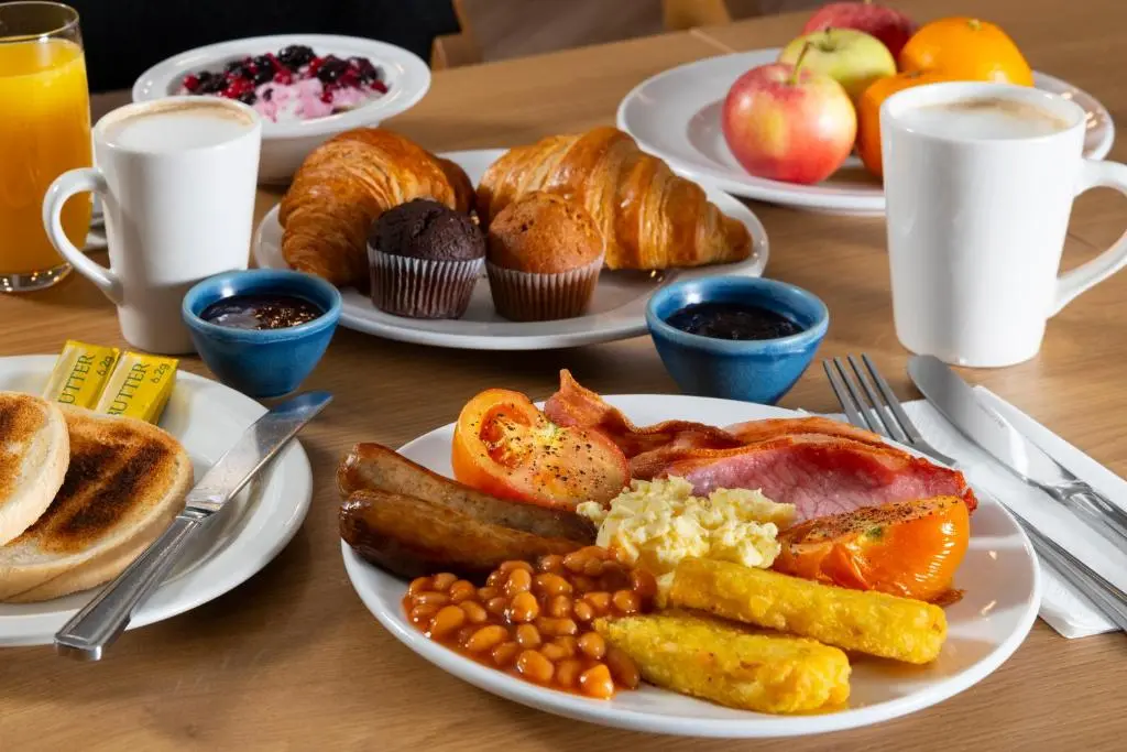 a table with plates of breakfast food on it at Holiday Inn Express Inverness by IHG in Inverness