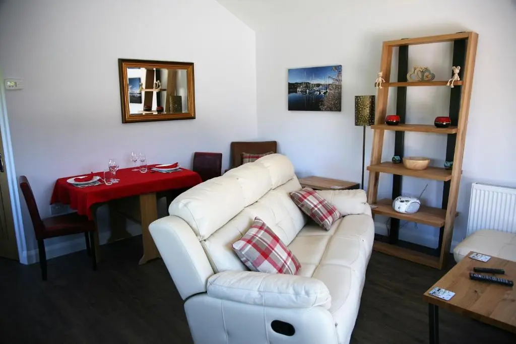 a living room with a white couch and a table at The Wee Lodge in Inverness
