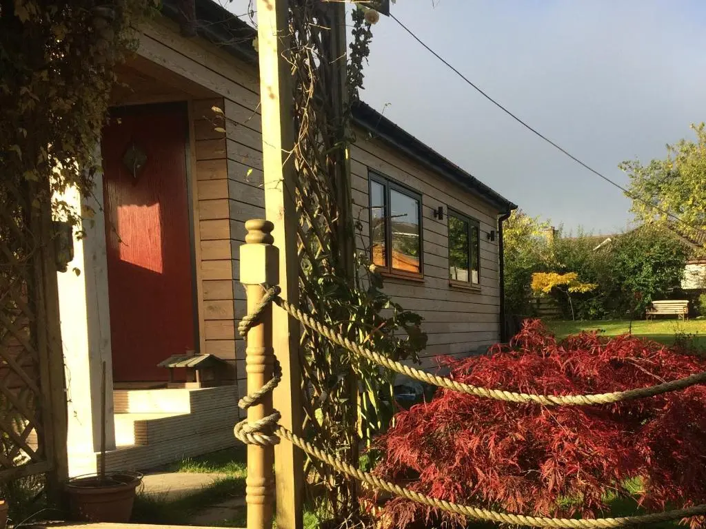 a house with a red bush in front of it at The Wee Lodge in Inverness