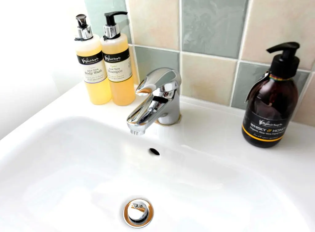 a bathroom sink with two bottles of soap and a soap dispenser at Albatross B&B Dornoch in Dornoch