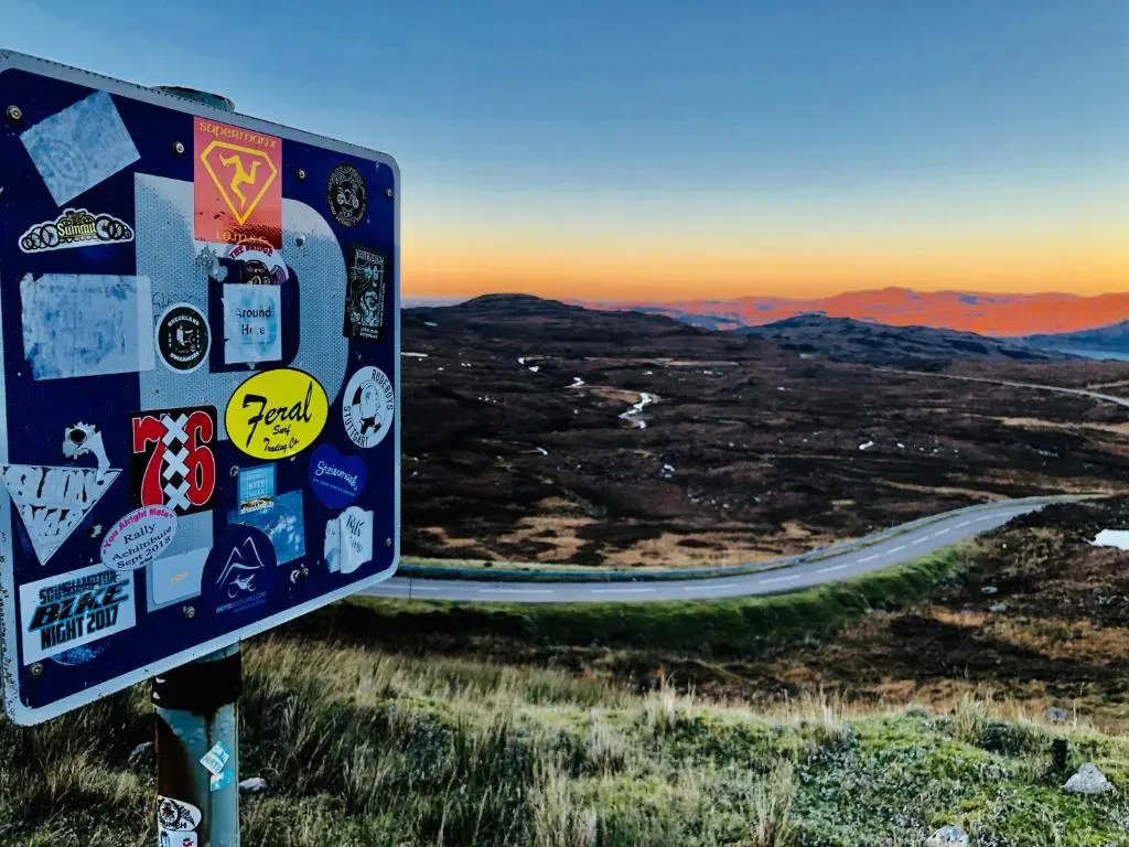 a sign with stickers on the side of a road at Albatross B&B Dornoch in Dornoch