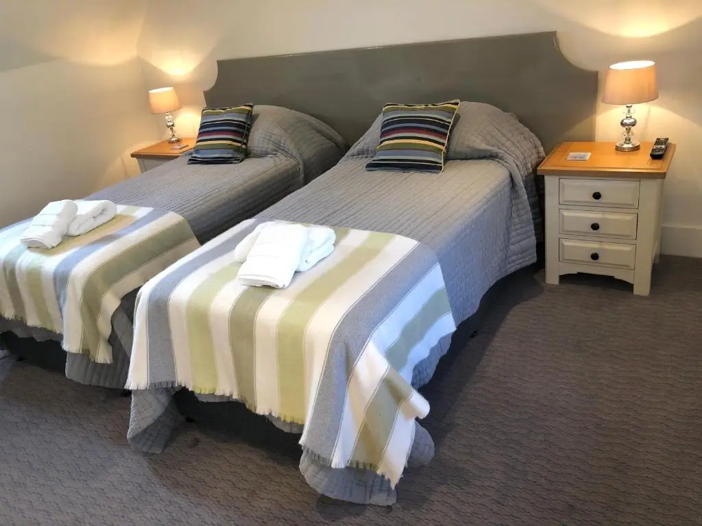 two beds in a hotel room with two night stands at Albatross B&B Dornoch in Dornoch