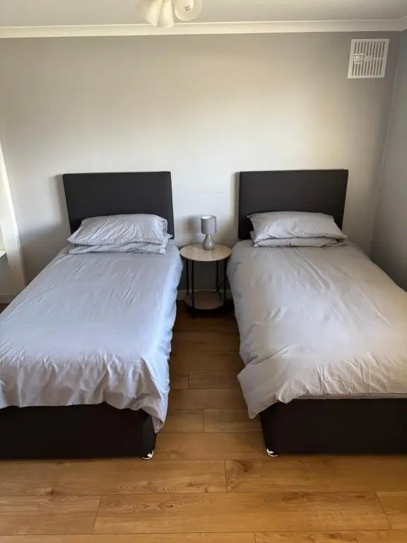 two beds sitting next to each other in a bedroom at Wick Apartment in Wick