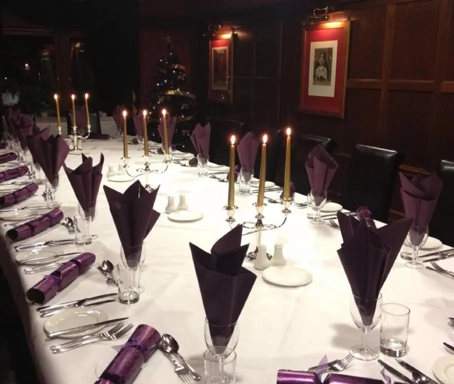 a long table with candles and napkins on it at The Craighaar Hotel in Aberdeen