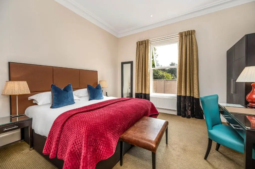 a bedroom with a bed and a desk and a window at Rocpool Reserve in Inverness