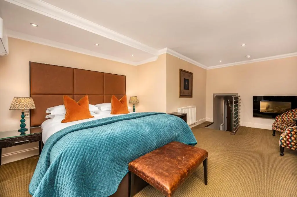 a large bedroom with a large bed with orange pillows at Rocpool Reserve in Inverness