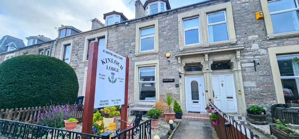 a brick house with a sign in front of it at mySTAYINN Kinloch Lodge in Inverness