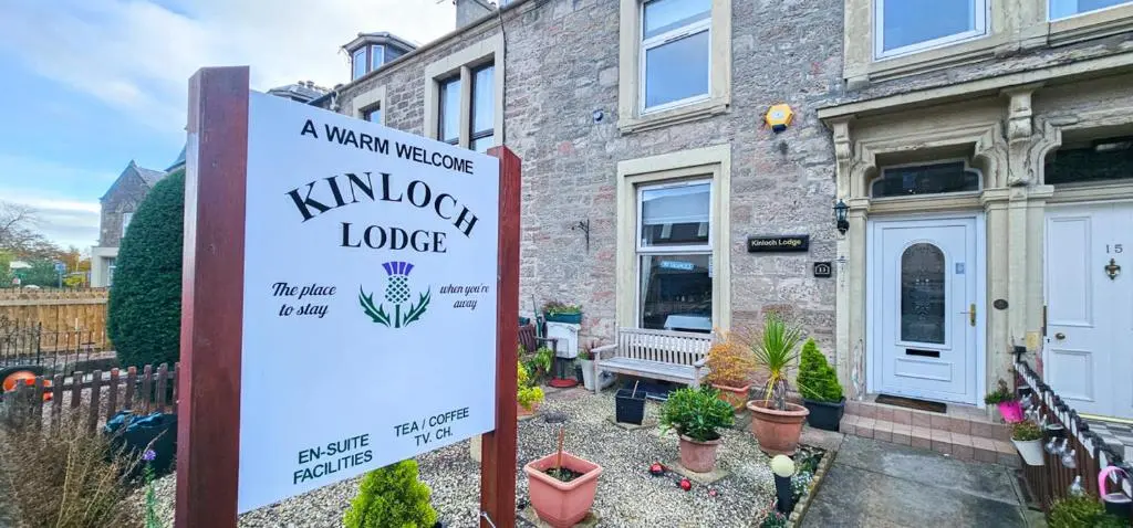 a sign in front of a house with a garden at mySTAYINN Kinloch Lodge in Inverness