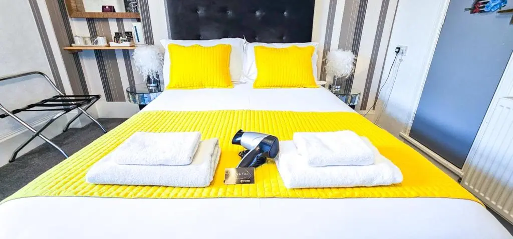 a large bed with towels and a hair dryer on it at mySTAYINN Kinloch Lodge in Inverness
