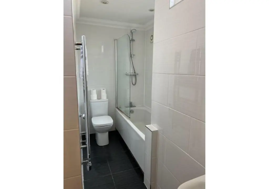 a bathroom with a shower and a toilet and a sink at The Waverley Inn Holiday Homes in Inverness