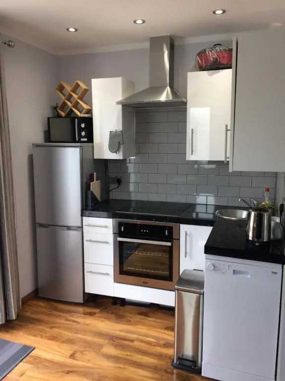 a kitchen with white cabinets and a stove top oven at 32a railside in Inverness