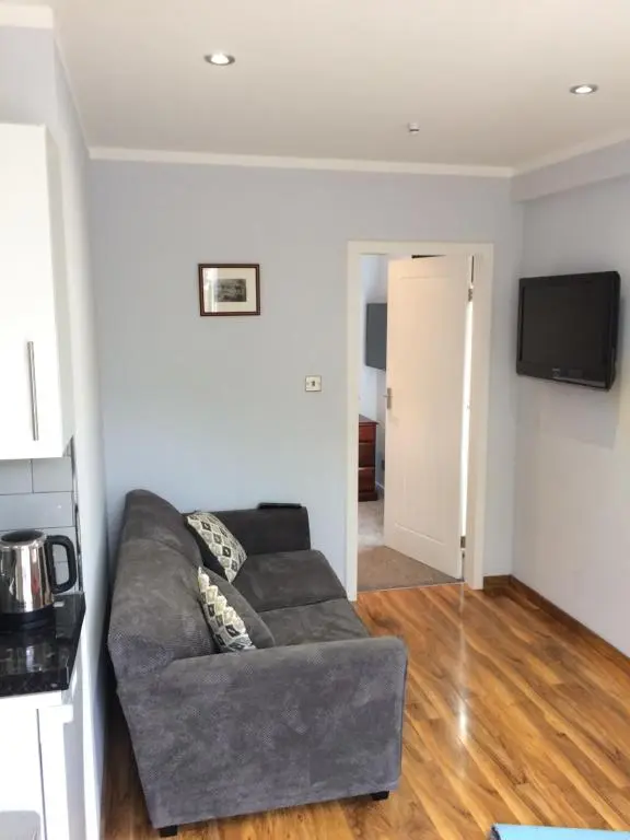 a living room with a couch and a flat screen tv at 32a railside in Inverness
