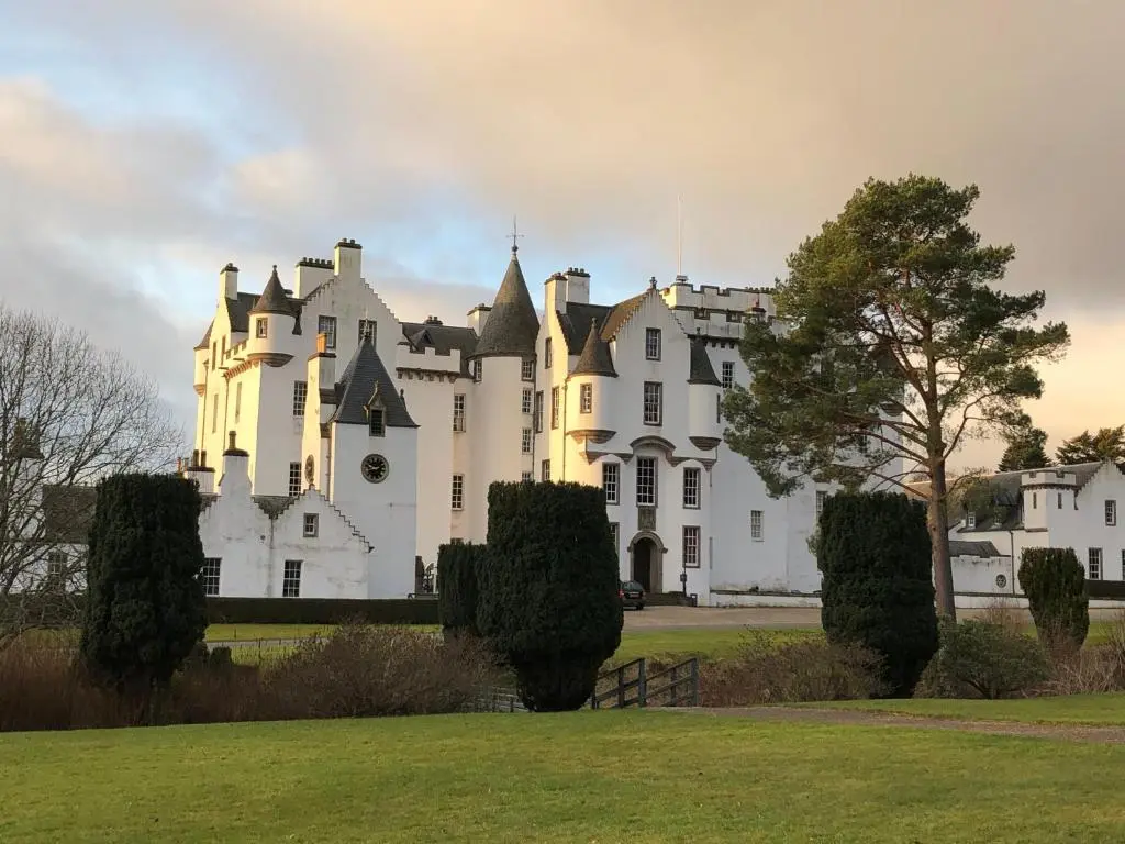 a large white castle with a tree in the foreground at Dalgreine Guest House in Blair Atholl