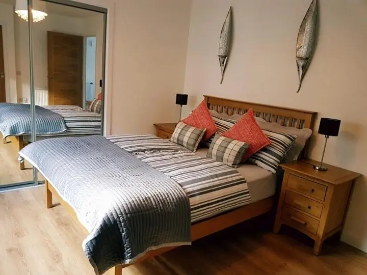 a bedroom with two beds and a mirror at Yvi's 2Bedroom 2Bathroom Apartment in Inverurie
