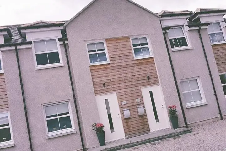 a large house with white doors and windows at Yvi's 2Bedroom 2Bathroom Apartment in Inverurie