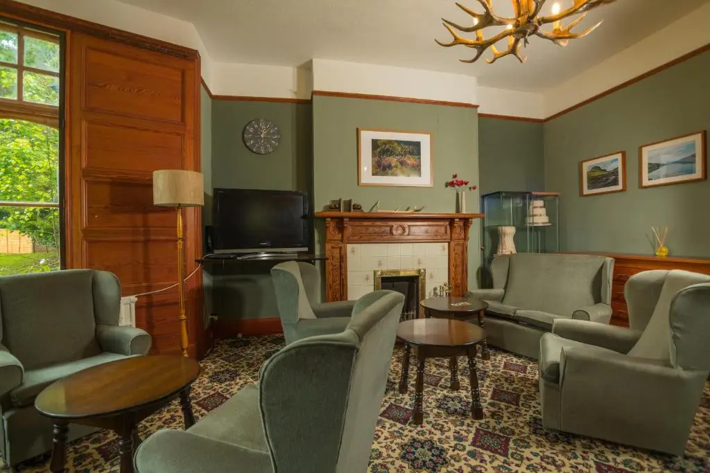 a living room with chairs and a fire place at Foyers Bay Country House in Foyers