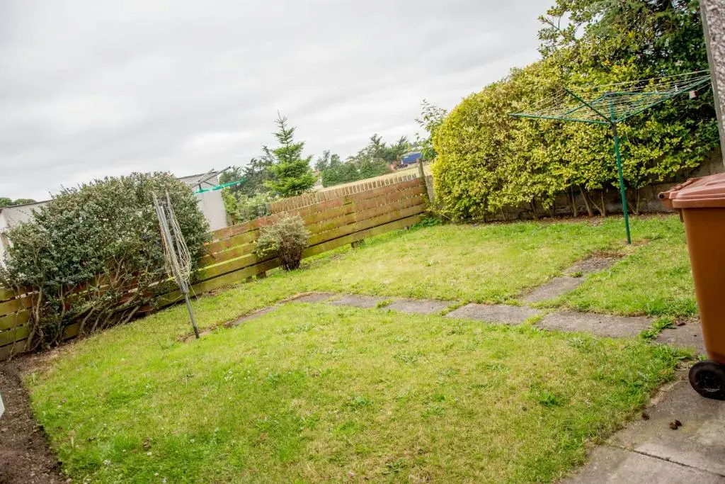 a backyard with a fence and a grass yard at Distillery Apartment 1 in Elgin