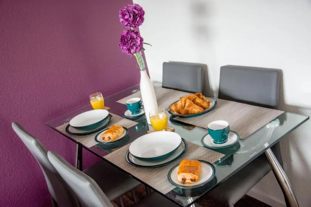 a table with plates of food and a vase with flowers at Distillery Apartment 1 in Elgin