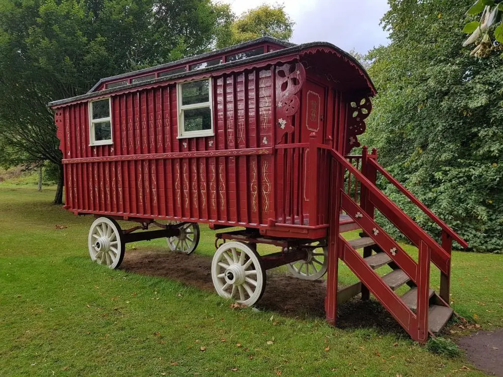 a red train car on display in a field at Distillery Apartment 1 in Elgin