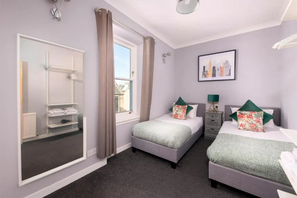 a bedroom with two beds and a window at Dryburgh Town House in Inverness