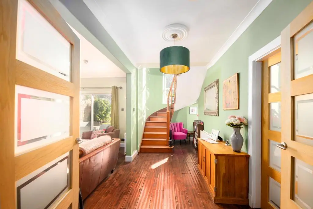 a living room with a staircase and green walls at Dryburgh Town House in Inverness