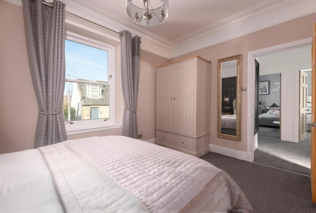 a bedroom with a bed and a large window at Dryburgh Town House in Inverness