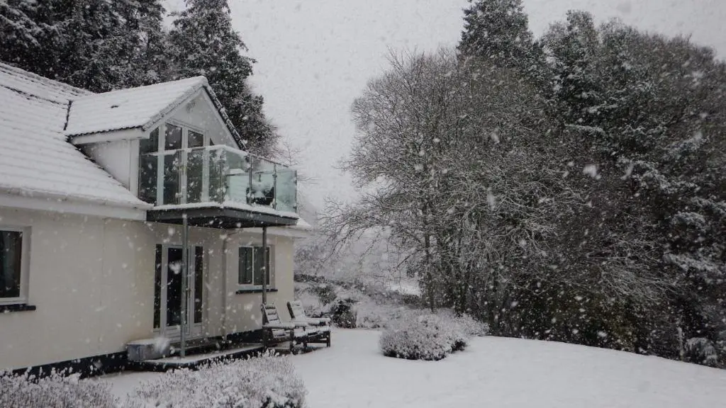 a house covered in snow with a balcony at High March in Drumnadrochit