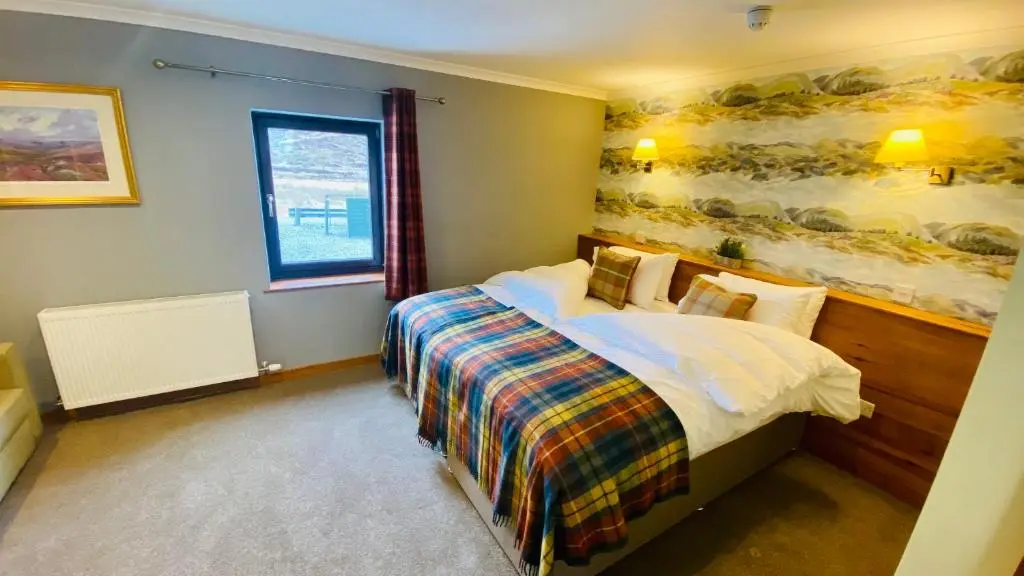 a bedroom with a bed and a painting on the wall at Aultguish Inn in Garve