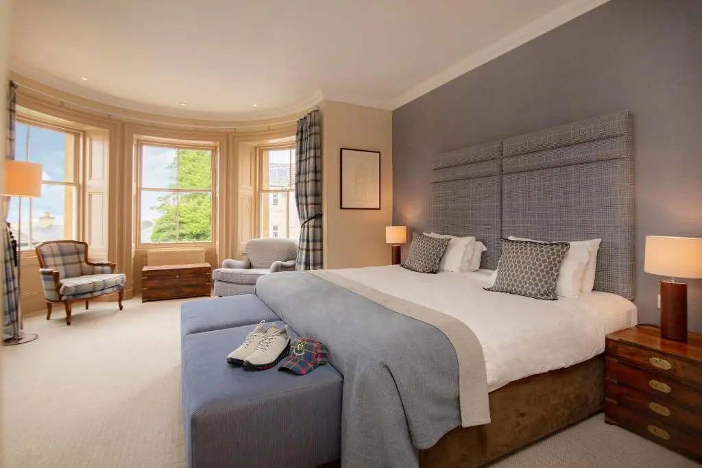 a bedroom with a large bed and a chair at Royal Golf Hotel, by Highland Coast Hotels in Dornoch