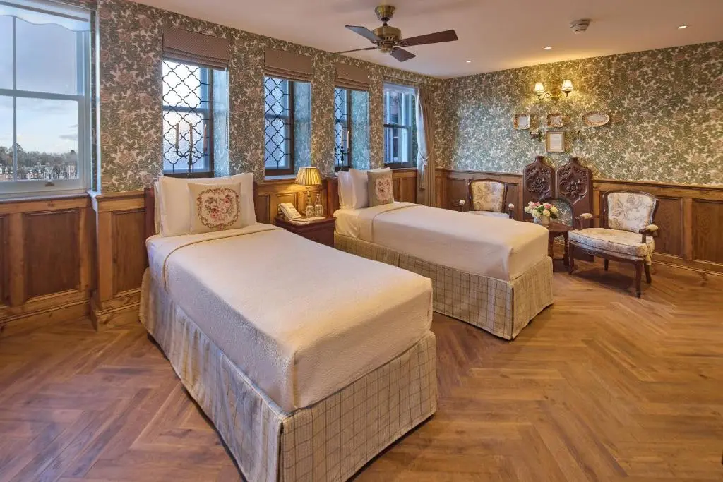 a hotel room with two beds and a chair at The Ambassador Hotel in Inverness