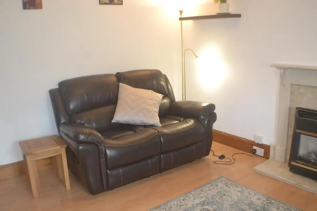a brown leather chair with a pillow in a living room at Strathallan B&B in Inverness
