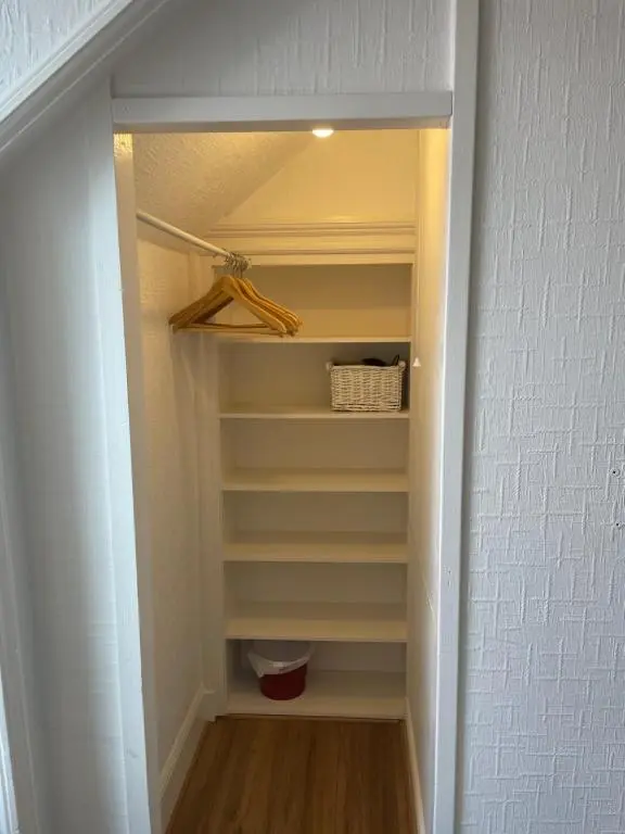 a walk in closet with white walls and shelves at Strathallan B&B in Inverness
