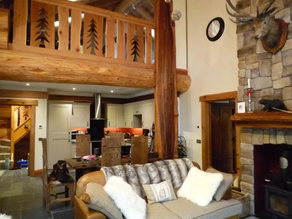 a living room with a couch and a fireplace at Caledonian Cabin in Invergarry