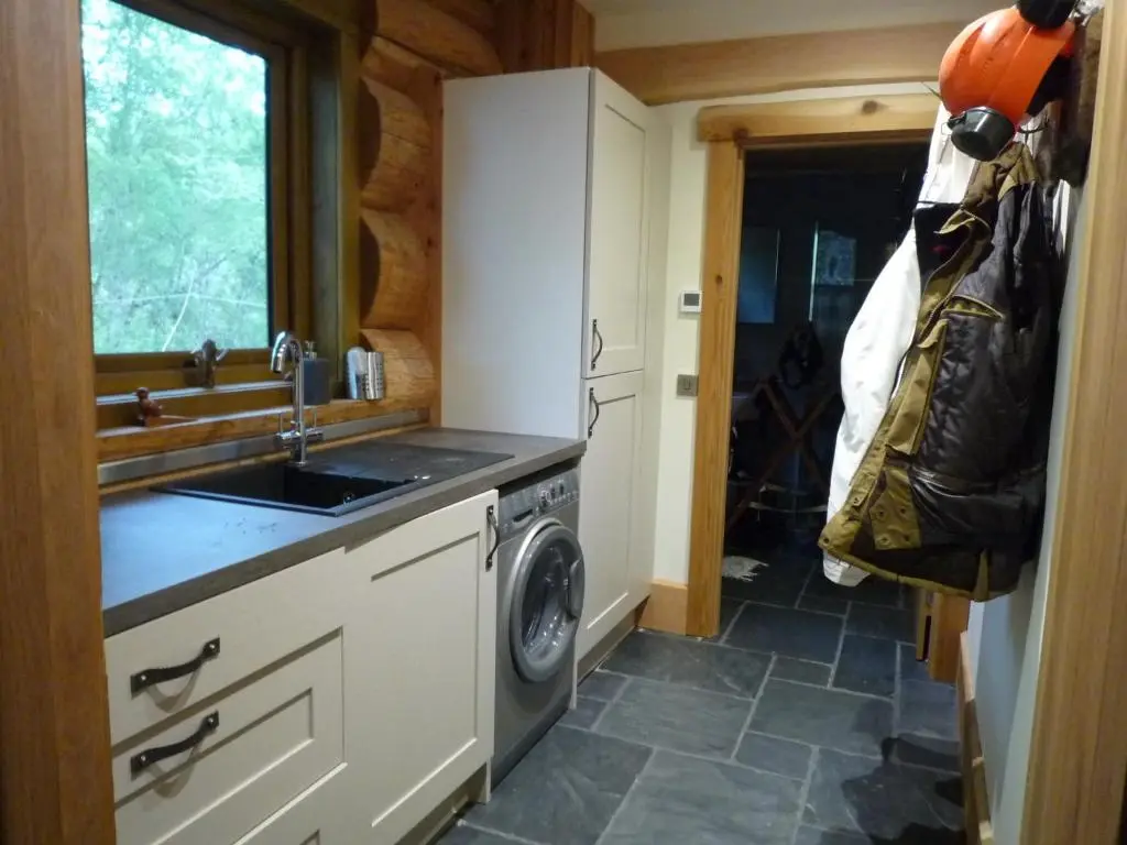 a kitchen with a sink and a washing machine at Caledonian Cabin in Invergarry