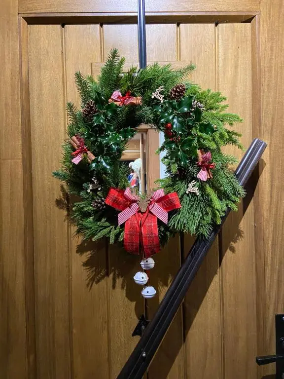 a christmas wreath is hanging on a wall at Caledonian Cabin in Invergarry