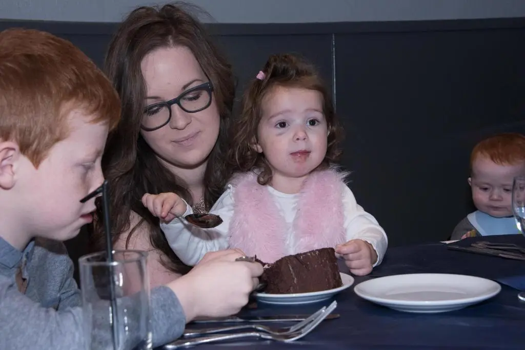 a woman and a little girl eating a chocolate cake at The Davron Hotel in Fraserburgh