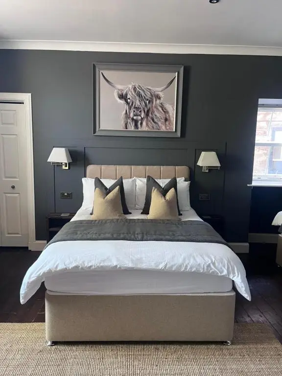 a bedroom with a large bed with blue walls at Fraser House in Inverness