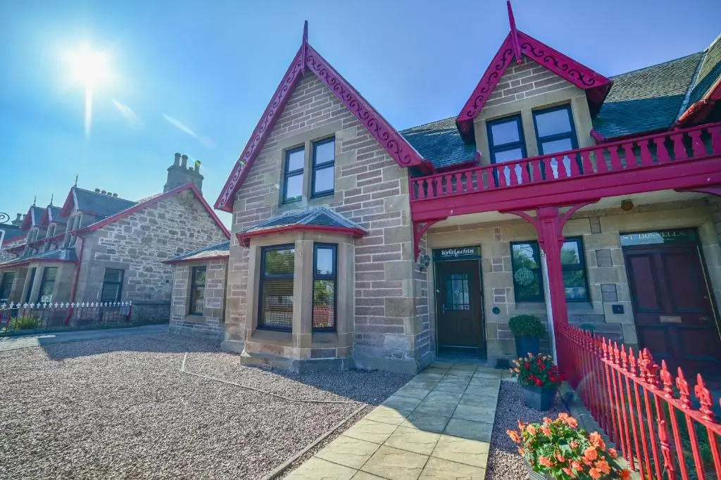 a large brick house with a red fence at Kylelachin in Dingwall
