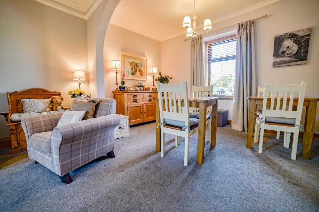 a living room with a table and chairs and a couch at Kylelachin in Dingwall