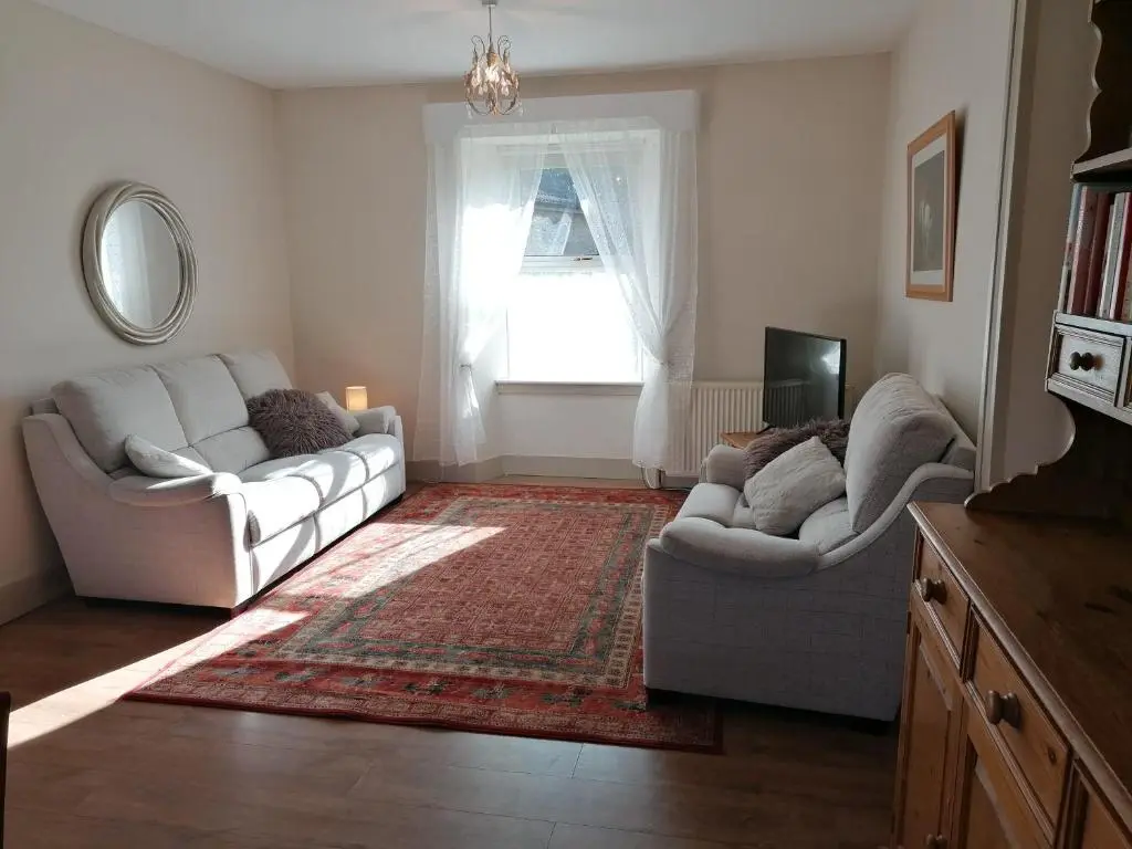 a living room with two couches and a window at Aberlour Cottages - Bolthole & Retreat in Aberlour