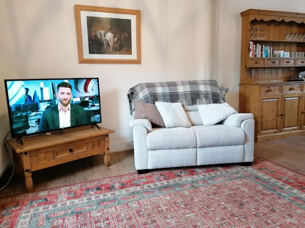 a living room with a couch and a tv at Aberlour Cottages - Bolthole & Retreat in Aberlour