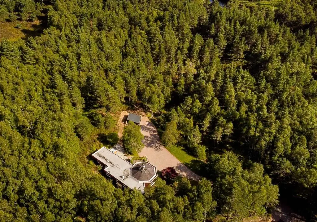 an aerial view of a house in the middle of a forest at Cairngorm Lodge Rothiemurchus in Aviemore
