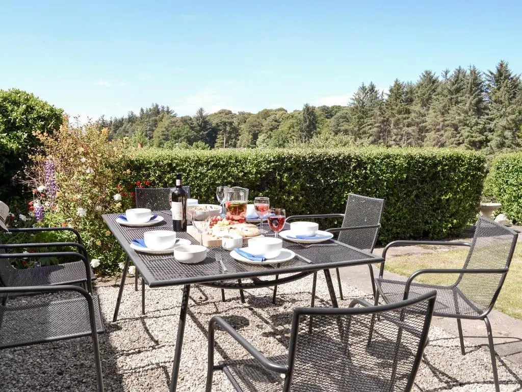 a black table with chairs and food on it at Auldfield in Lhanbryd