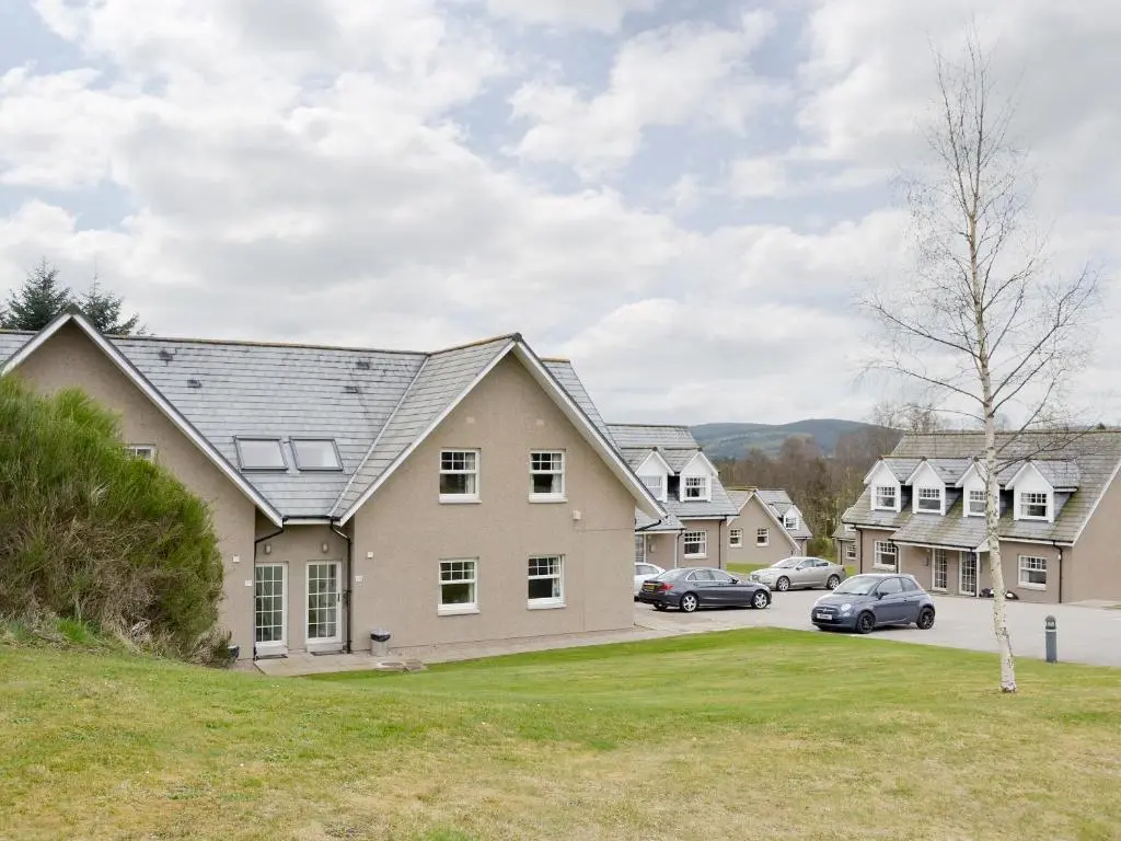 a house with cars parked in a parking lot at 22 Queens Court in Inchmarlo