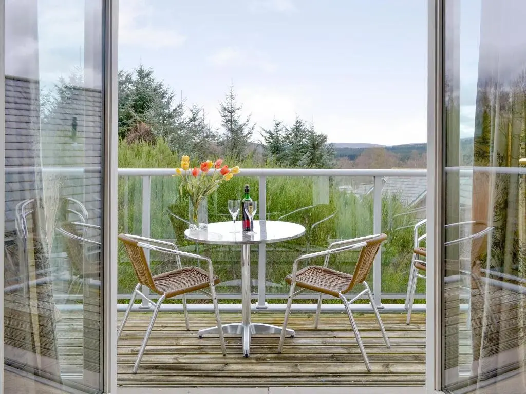 a balcony with a table and chairs on a deck at 32 Queens Court in Inchmarlo